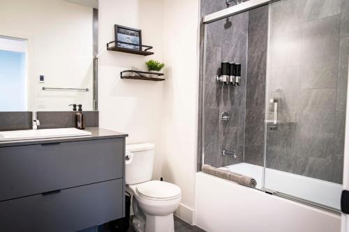 a bathroom with a shower and a toilet and a sink at The Three Bear Penthouse - with Hot Tub in Revelstoke