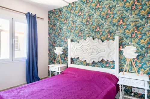 a bedroom with a purple bed with a floral wallpaper at Casa Tropicana in Paul do Mar