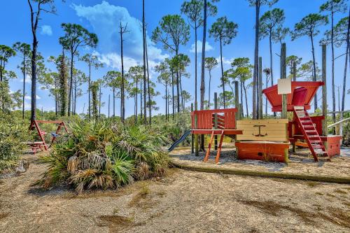 a playground with colorful equipment in a field with trees at Luau 6909 in Destin