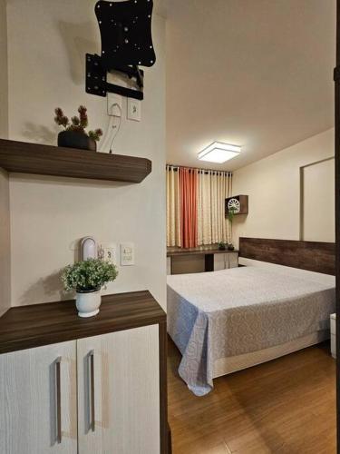 een slaapkamer met een bed in een kamer bij Loft Premier Centro e 800 mt da Oktoberfest. in Blumenau