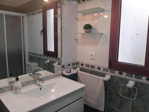 een badkamer met een wastafel en een spiegel bij El apartamento de MATITA - free parking and beach in Telde