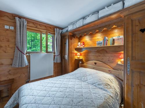 une chambre avec un lit et un mur en bois dans l'établissement Charmant 2 pièces avec piscine, spa et accès direct pistes à Méribel Village - FR-1-566-60, à Les Allues