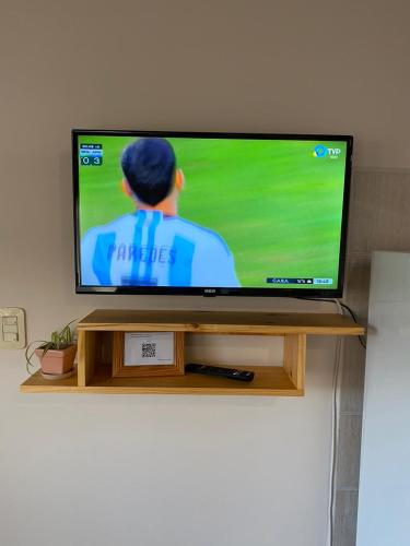 TV de pantalla plana con soporte de madera en El Amanecer en Esquel