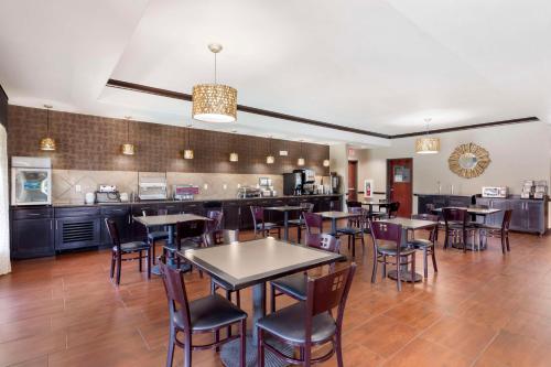 a restaurant with tables and chairs and a kitchen at Best Western Plus Classic Inn and Suites in Center