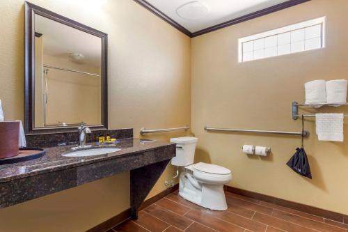 a bathroom with a toilet and a sink and a mirror at Best Western Plus Classic Inn and Suites in Center