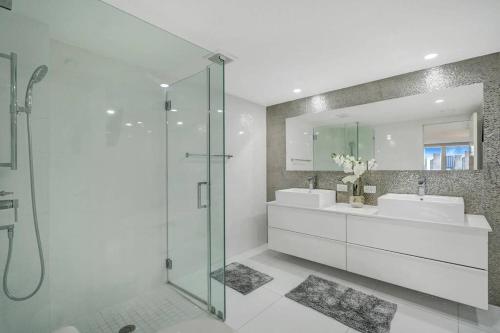 baño con 2 lavabos y ducha de cristal en Funkin' Fabulous! Water & City Views! 4BR, en Miami
