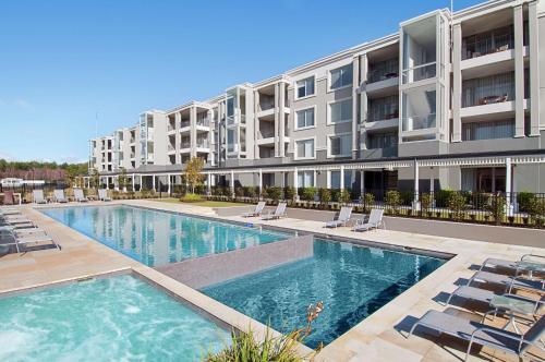 a swimming pool in front of a apartment building at Hilton Lake Taupo in Taupo