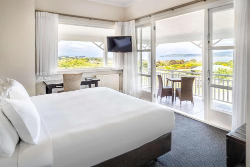 a hotel room with a bed and a balcony at Hilton Lake Taupo in Taupo