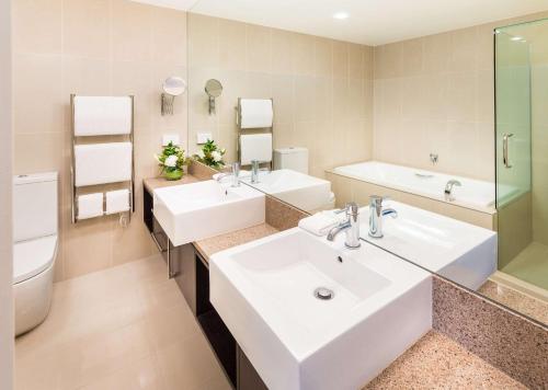 a bathroom with two sinks and a toilet at Hilton Lake Taupo in Taupo