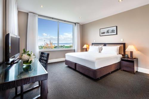 a hotel room with a bed and a large window at Hilton Lake Taupo in Taupo