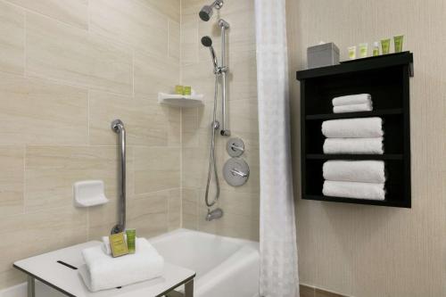 y baño con ducha, bañera y toallas. en Hilton Orlando/Altamonte Springs, en Orlando