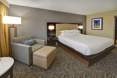 a hotel room with a bed and a chair at Hilton Orlando/Altamonte Springs in Orlando