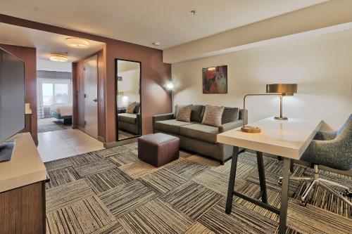 a hotel room with a desk and a couch at Hilton Garden Inn Albuquerque/Journal Center in Albuquerque