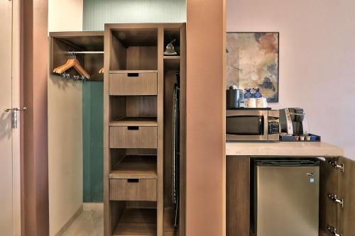 a kitchen with a refrigerator and a counter with a microwave at Hilton Garden Inn Albuquerque/Journal Center in Albuquerque