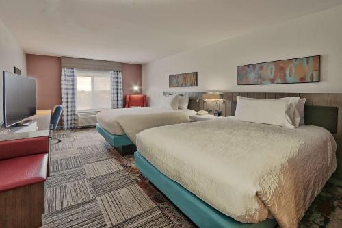 um quarto de hotel com duas camas e uma televisão de ecrã plano em Hilton Garden Inn Albuquerque/Journal Center em Albuquerque