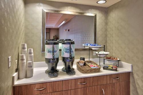 a bathroom with two water machines on a counter with a mirror at Hilton Garden Inn Albuquerque/Journal Center in Albuquerque