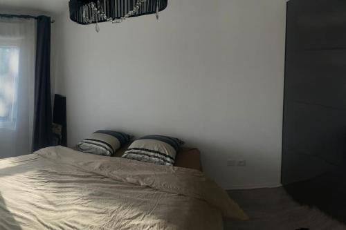 een bed in een slaapkamer met een witte muur bij Appartement Aéroport Orly in Athis-Mons