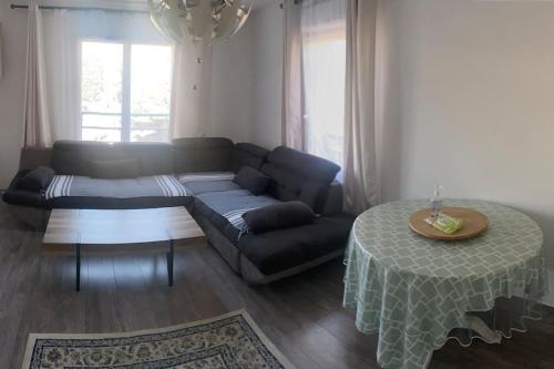 een woonkamer met een bank en een tafel bij Appartement Aéroport Orly in Athis-Mons