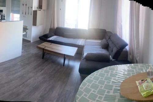 een woonkamer met een bank en een salontafel bij Appartement Aéroport Orly in Athis-Mons