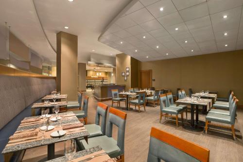 Un comedor con mesas y sillas en un restaurante. en Hilton Baltimore BWI Airport, en Linthicum