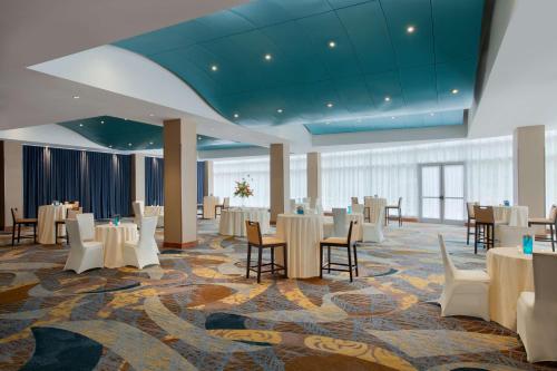 a banquet hall with white tables and chairs at Hilton Baltimore BWI Airport in Linthicum Heights