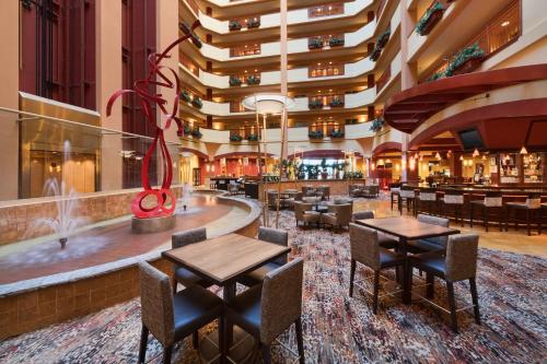 a hotel lobby with tables and chairs and a bar at Embassy Suites Murfreesboro - Hotel & Conference Center in Murfreesboro