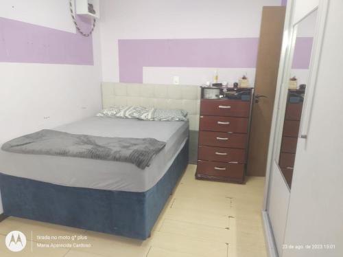 ein kleines Schlafzimmer mit einem Bett und einer Kommode in der Unterkunft Casa individual no bairro da Velha em Blumenau in Blumenau