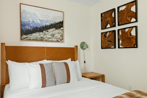 Heart of Olde Town - Urban Retreat - 95 Walk Score في أرفادا: غرفة نوم بسرير وثلاث صور على الحائط