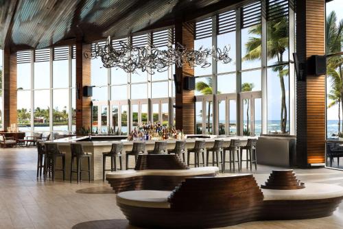 un restaurante con un bar con sillas y ventanas en Caribe Hilton en San Juan