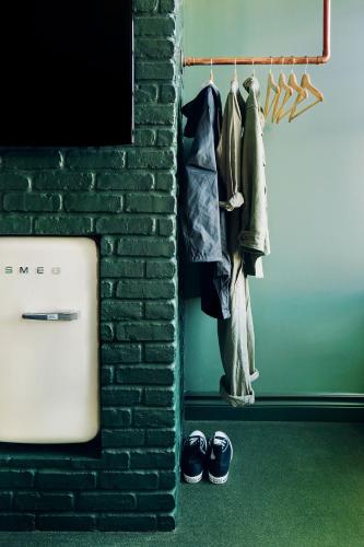 a room with a brick wall and a rack of clothes and shoes at Palihotel Seattle in Seattle
