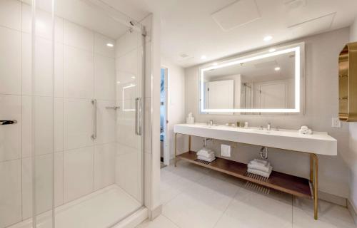 a bathroom with a sink and a shower and a mirror at Hilton Québec in Quebec City
