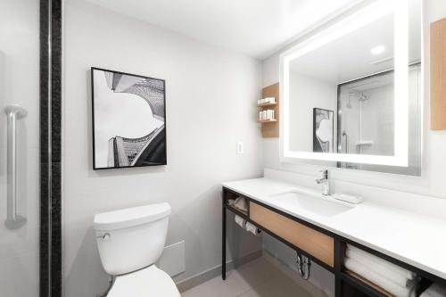 a bathroom with a toilet and a sink and a mirror at Hilton Garden Inn Toronto Airport in Mississauga