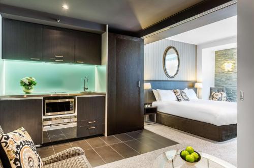 a hotel room with a bed and a kitchen at DoubleTree by Hilton Queenstown in Queenstown