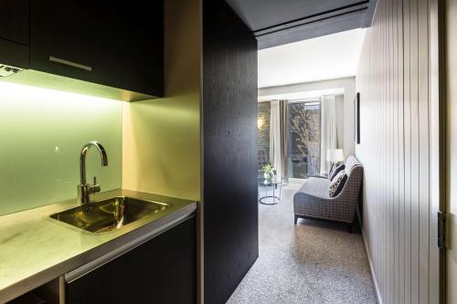 a kitchen with a sink and a living room at DoubleTree by Hilton Queenstown in Queenstown