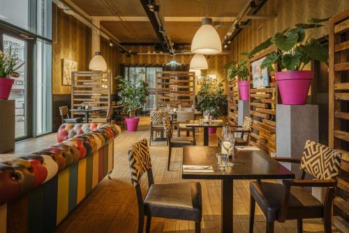 a restaurant with tables and chairs and potted plants at DoubleTree by Hilton Amsterdam - NDSM Wharf in Amsterdam