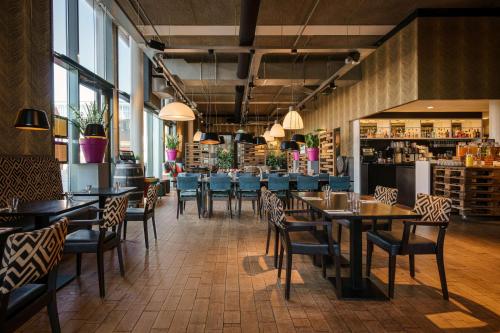 un ristorante con tavoli e sedie e un bar di DoubleTree by Hilton Amsterdam - NDSM Wharf ad Amsterdam