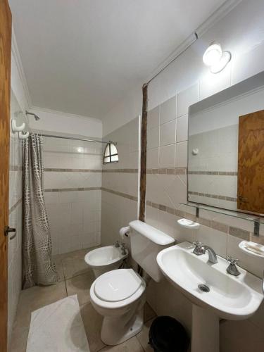 y baño con aseo, lavabo y espejo. en don isidro habitacion matrimonial en La Paz