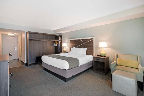 a hotel room with a bed and a chair at Best Western Plus Daytona Inn Seabreeze in Daytona Beach