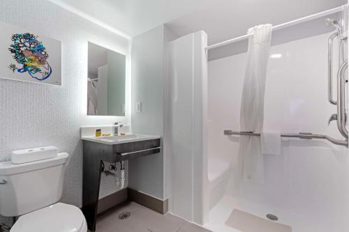 a bathroom with a toilet and a sink and a shower at Best Western Plus Daytona Inn Seabreeze in Daytona Beach