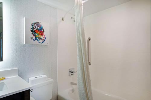 a white bathroom with a shower and a toilet at Best Western Plus Daytona Inn Seabreeze in Daytona Beach
