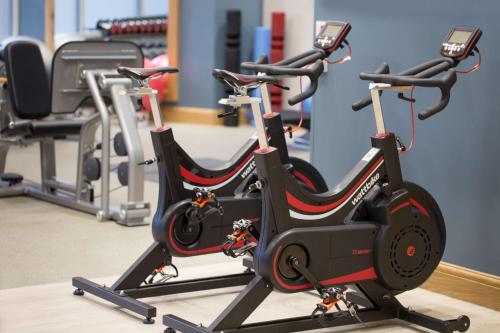 a row of exercise bikes in a gym at Hilton Cambridge City Centre in Cambridge