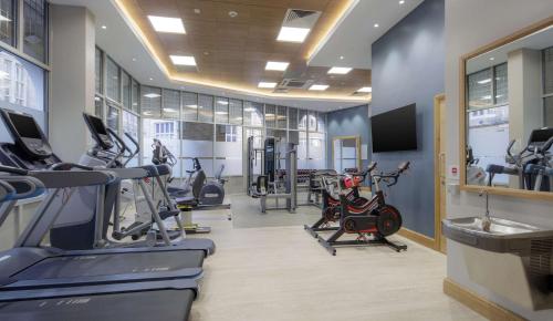 a gym with treadmills and cardio machines in a room at Hilton Cambridge City Centre in Cambridge