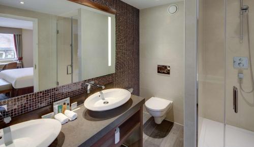 a bathroom with a sink and a toilet and a shower at Hilton Cambridge City Centre in Cambridge