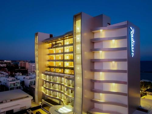 a view of a hotel at night at Radisson Beach Resort Larnaca in Larnaka