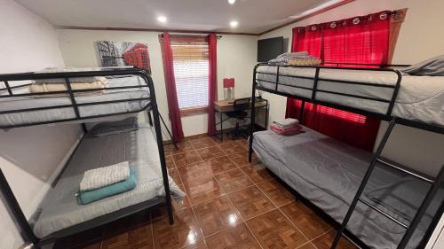 a room with three bunk beds and a wooden floor at Alojamiento Los Andes in Brownsville