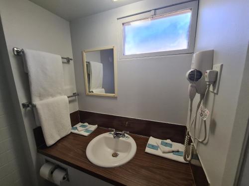 a bathroom with a sink and a hair dryer at Sundowner Motel in Cache Creek