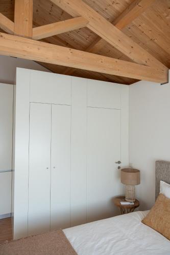 a bedroom with white walls and a wooden ceiling at Quinta da Ribeirinha - Douro River in Paços de Gaiolo
