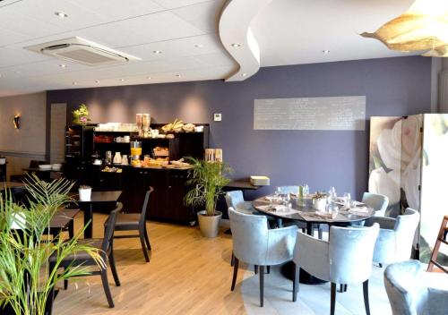 a restaurant with tables and chairs and a counter at Hotel le Broceliande - Sure Hotel Collection by Best Western in Bédée