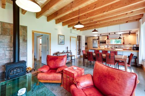 a living room with red chairs and a stove at Acadia Home with Rooftop Deck - Close to Trails! in Otter Creek