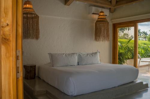 een wit bed in een kamer met een raam bij Rancho Eden in Armenia